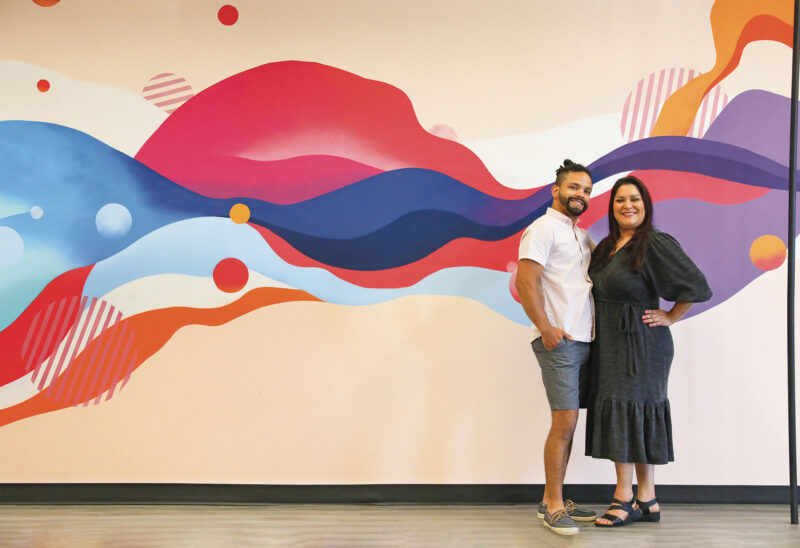 Manuel Ramirez and Cecilia Ulibarri in front of a mural painted by Cecilia in the new headquarters of Positive Street Art in Nashua. (Photo by Cheryl Senter.)