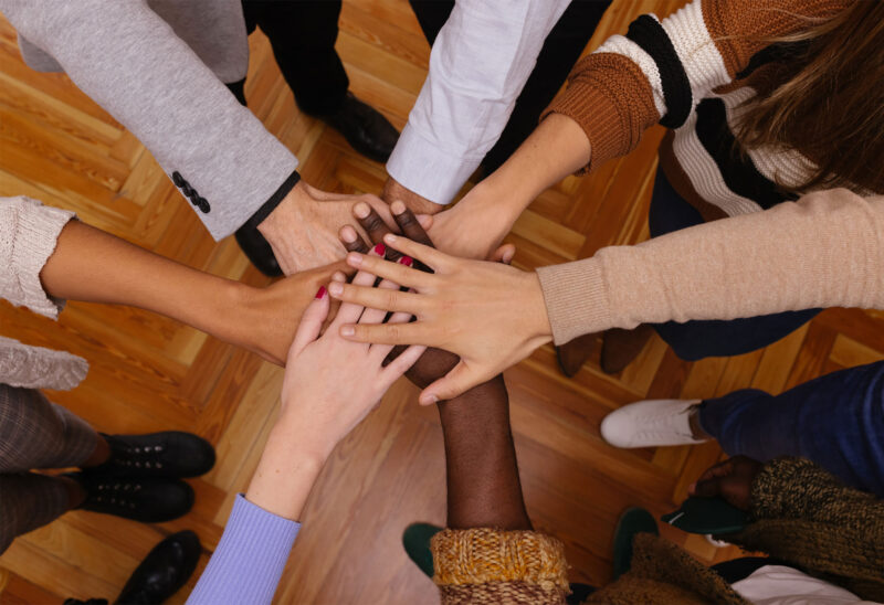 People joining hands in a circle.