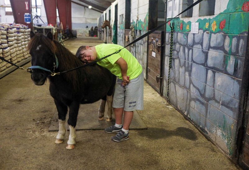 UpReach Therapeutic Equestrian Center has made a profound difference in the life of Kim and Steve Tiller's son Ty, who has Down syndrome, and been riding horses at UpReach for 8 years. (Photo by Cheryl Senter.)
