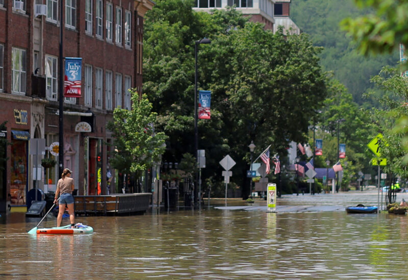 A person rows a paddle board in a flooded area in Montpelier, Vermont, U.S. on July 11, 2023. (Photo courtesy of Brian
